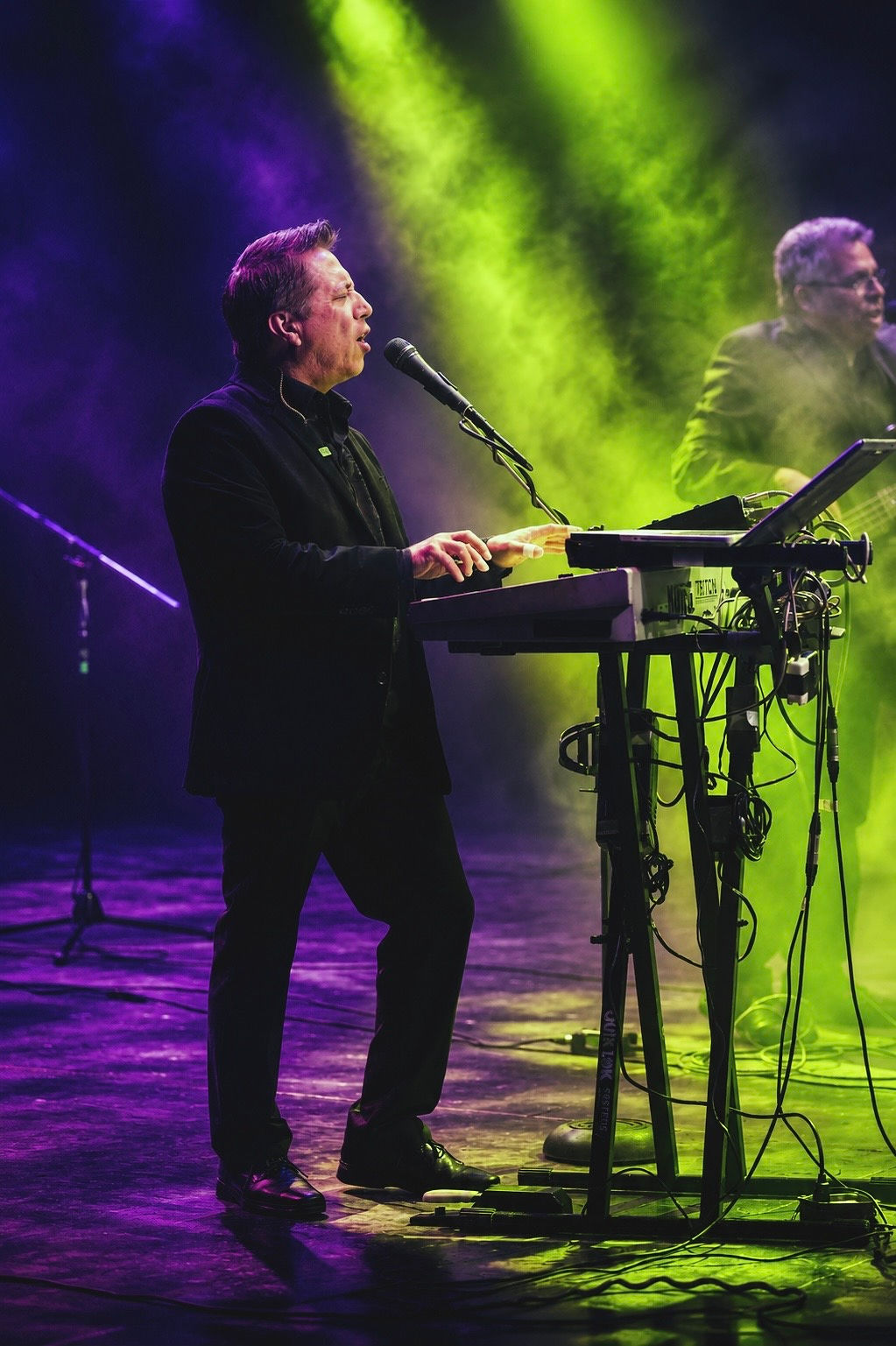 Alejandro Tornero performing under gold and violet stage lights